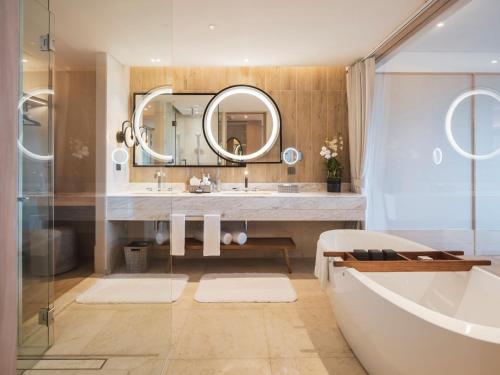 uma casa de banho com uma banheira, um lavatório e um espelho. em Anantara Koh Yao Yai Resort & Villas em Ko Yao Yai