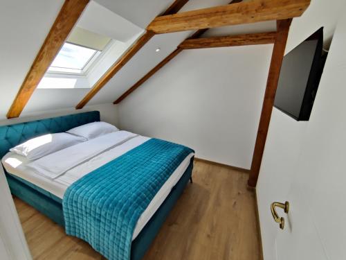 a bedroom with a bed and a television in a attic at Kuća za odmor Villa Cesarica - Zagreb in Graberje Ivanićko