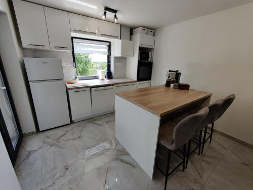 a kitchen with white cabinets and a wooden counter top at Kuća za odmor Villa Cesarica - Zagreb in Graberje Ivanićko