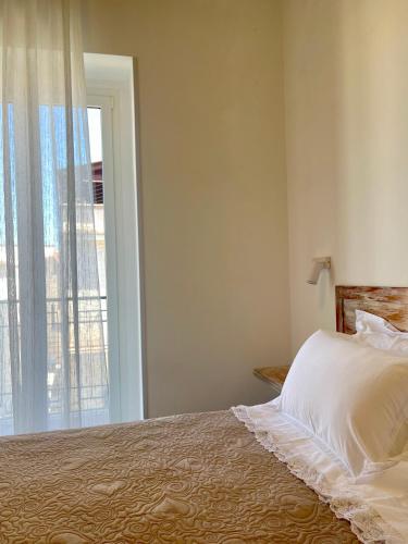 a bedroom with a bed and a large window at La Casa dei Nonni B&B in Vieste