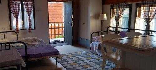 a room with beds and a table and windows at Garičkina kuća 2 in Pirot