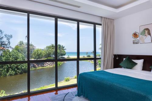 a bedroom with a view of the ocean at Ocean Sunny Villas Da Nang in Da Nang