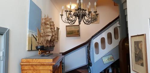 a hallway with a staircase with a chandelier at Apartments in der Blocksquerstraße in Lübeck
