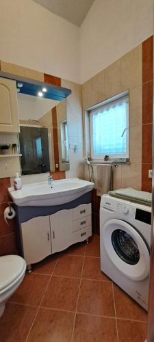 a bathroom with a sink and a washing machine at Apartments Villa Bella Vista Hvar in Hvar