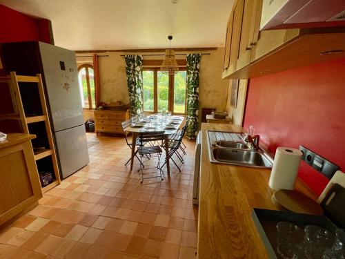 a kitchen with a table with chairs and a sink at Maison avec jardin - L'Orangerie in Thouaré-sur-Loire