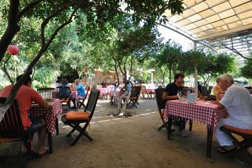 a group of people sitting at tables in a restaurant at Hotel Gumusluk in Gümüşlük