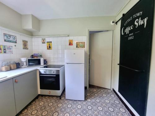 a kitchen with a refrigerator and a chalkboard on the wall at Le B'Rock in Liévin