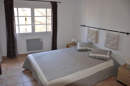 une chambre avec un grand lit et une fenêtre dans l'établissement Mas La Provence, à Rustrel