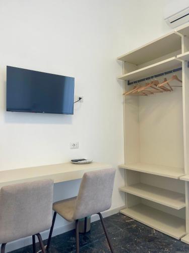 a desk with two chairs and a tv on a wall at La Casa dei Nonni B&B in Vieste