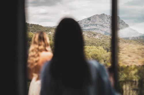 two people looking out a window at a mountain at Les Lodges Sainte-Victoire Hotel & Spa in Aix-en-Provence