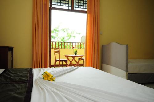 a bedroom with a bed with yellow flowers on it at Hotel Sobana Lake front in Udawalawe