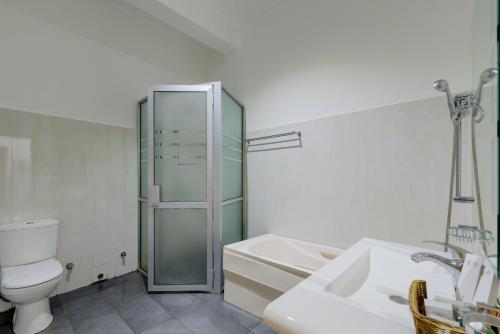 a bathroom with a toilet and a shower and a sink at Hotel Sobana Lake front in Udawalawe