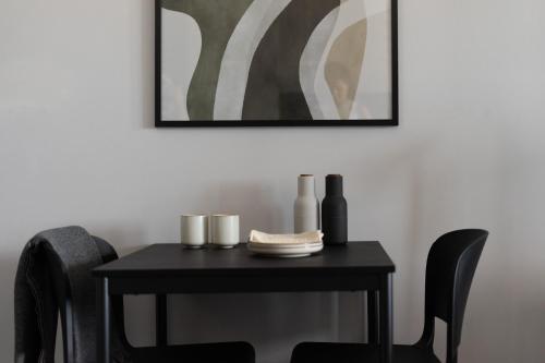 uma mesa preta com cadeiras e uma foto na parede em Park Heights by the Warren Collection em Msida
