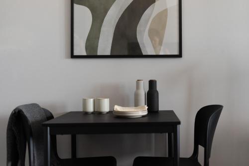 a black table with chairs and a picture on the wall at Park Heights by the Warren Collection in Msida