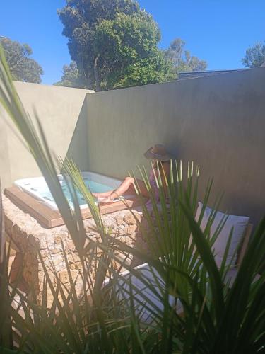 a person is laying in a swimming pool at Hôtel Les Suites Du Maquis in Bonifacio