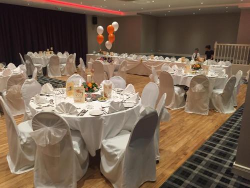 a banquet hall with white tables and chairs and balloons at Percy French Hotel in Strokestown