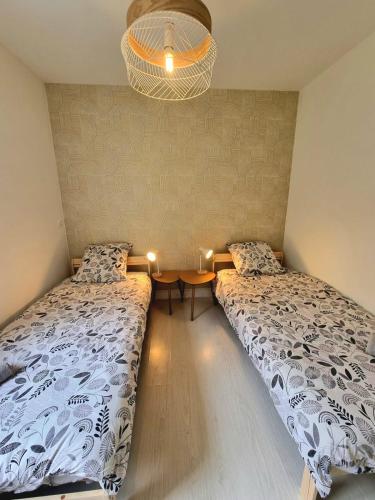 a bedroom with two beds and a table with lights at Le B'Rock in Liévin