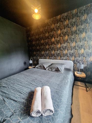 a bedroom with a bed with two towels on it at Le B'Rock in Liévin