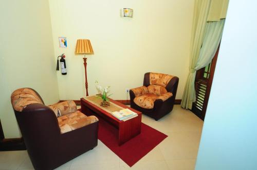 a living room with two chairs and a coffee table at Hotel Sobana Lake front in Udawalawe