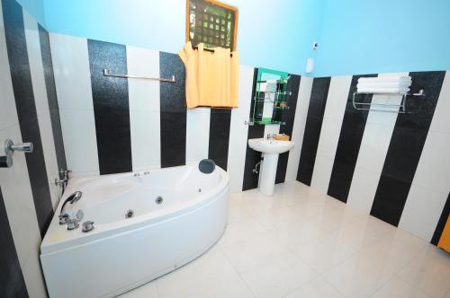 a bathroom with a tub and a toilet and a sink at Hotel Sobana Lake front in Udawalawe