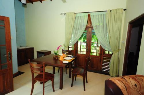 a dining room with a table and chairs and a window at Hotel Sobana Lake front in Udawalawe