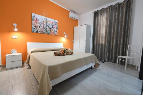 a bedroom with a bed with an orange wall at AL Quadrifoglio in Terrasini