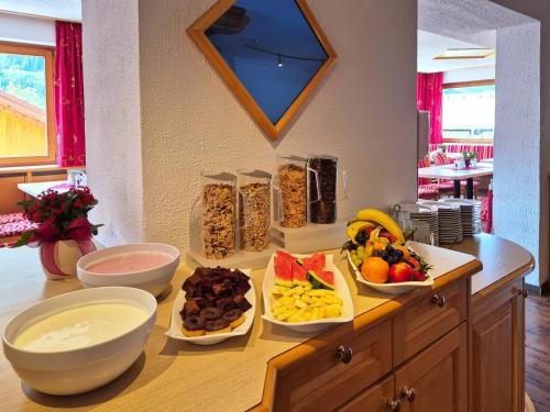 a counter with bowls of fruits and vegetables on it at Alpenpension Gastein in Bad Gastein