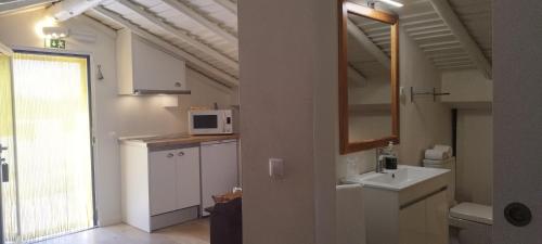 a small kitchen with a sink and a microwave at Quinta da Soneca in Alandroal