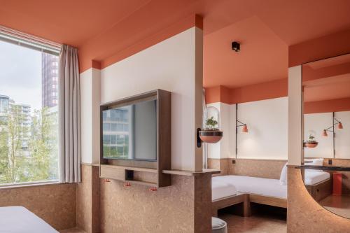a bathroom with a large window and a tv at The Usual Rotterdam in Rotterdam