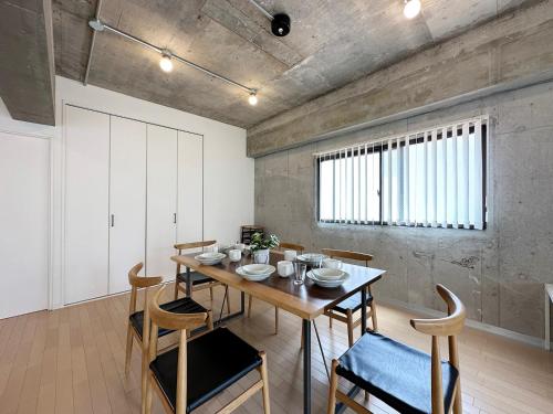 a dining room with a wooden table and chairs at b hotel M's lea - Modern Spacious Apartment Beside Peace Park 10 ppl in Hiroshima