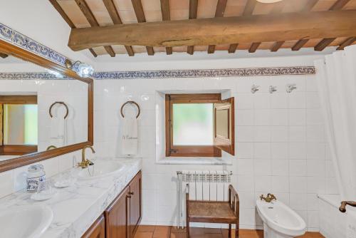 Baño blanco con 2 lavabos y espejo en Cal Masover, en Sant Boi de Lluçanès