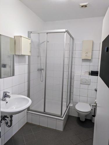 a bathroom with a shower and a toilet and a sink at interaktiv Appartements in Ratingen - Düsseldorferstrasse in Ratingen