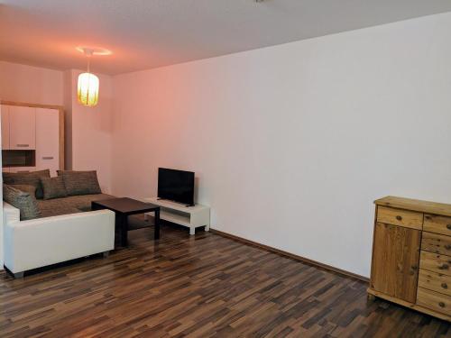a living room with a couch and a television at interaktiv Appartements in Ratingen - Düsseldorferstrasse in Ratingen