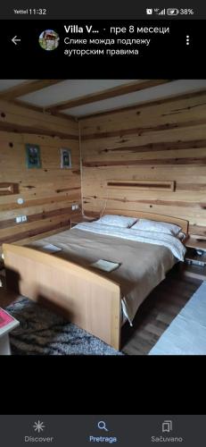 a large bed in a room with wooden walls at Vila VRABAC in Priboj