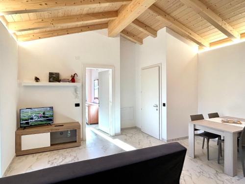 Una sala de estar con un televisor y una mesa. en Appartamento CS, en Sabbionara