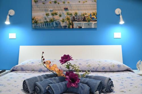 a bedroom with a bed with a blue wall at AL Quadrifoglio in Terrasini