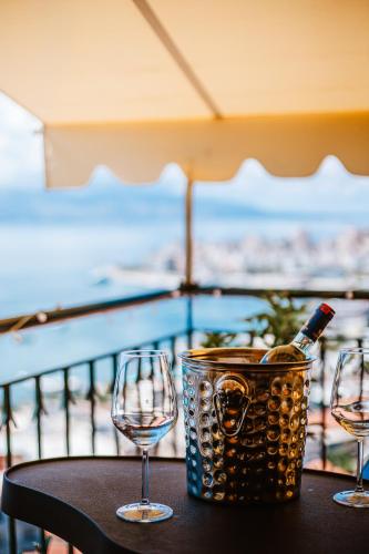 three wine glasses and a bottle of wine on a table at Lost At Sea in Sarandë