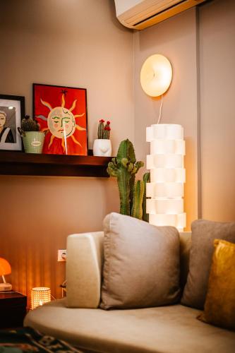 a living room with a couch and a shelf with a cactus at Lost At Sea in Sarandë