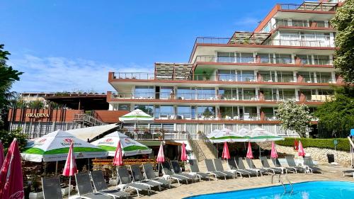 ein Hotel mit Stühlen und Sonnenschirmen neben einem Pool in der Unterkunft BSA Gradina Hotel - All Inclusive & Private Beach in Goldstrand