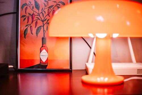 a lamp and a picture of a bottle on a table at Lost At Sea in Sarandë