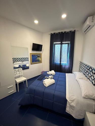 a bedroom with a blue bed with towels on it at la divina bed&breakfast in Battipaglia