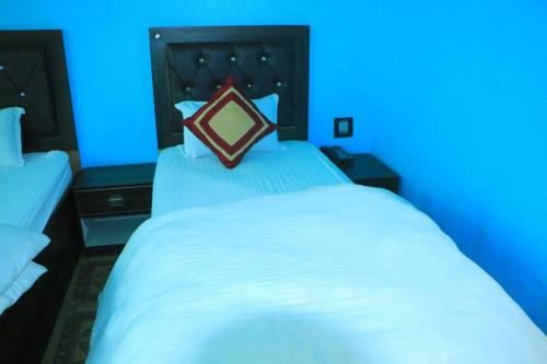 a bedroom with a large white bed with a blue light at Hotel Diamond in Bharatpur