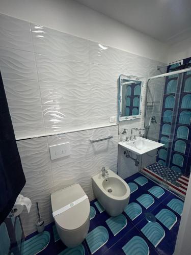 a bathroom with a white toilet and a sink at la divina bed&breakfast in Battipaglia