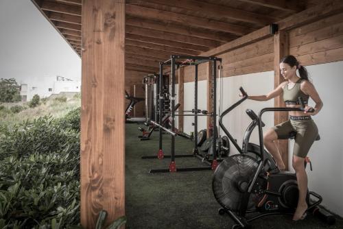 a woman riding a bike in a gym at VAYA Suites by Omilos Hotels in Amoudara Herakliou