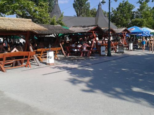 a group of people sitting at tables at a restaurant at Munkácsy Apartmanok in Balatonfenyves