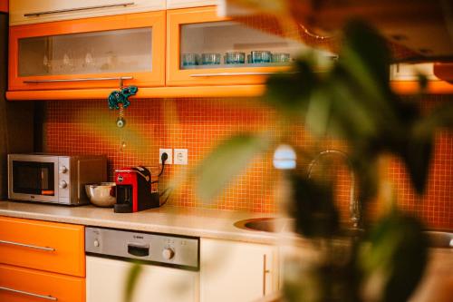 a kitchen with a sink and orange tiled walls at Lost At Sea in Sarandë