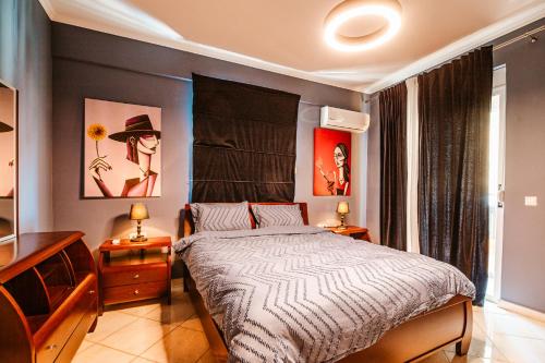 a bedroom with a bed and two lamps and paintings at Lost At Sea in Sarandë