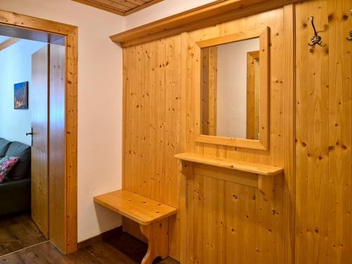 a wooden cabinet with a mirror and a bench at Alpenpension Gastein in Bad Gastein