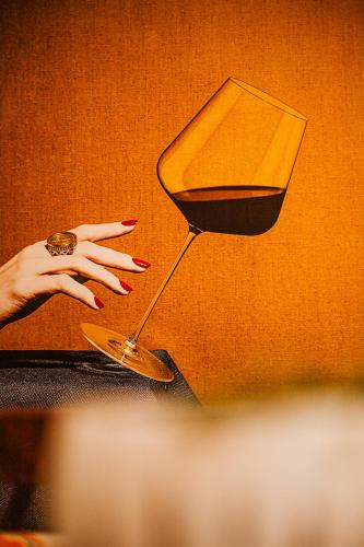 a hand reaching for a glass of wine at Lost At Sea in Sarandë