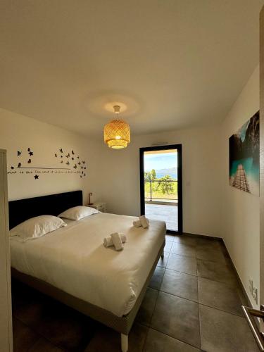 une chambre avec un grand lit avec des serviettes dessus dans l'établissement T2 neuf vue mer proximite plage, à Propriano